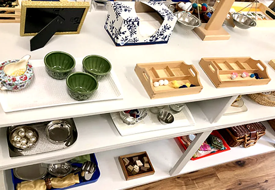 Ordered Montessori materials on shelves in the Primary classroom at Peridot Montessori in Madison, Alabama